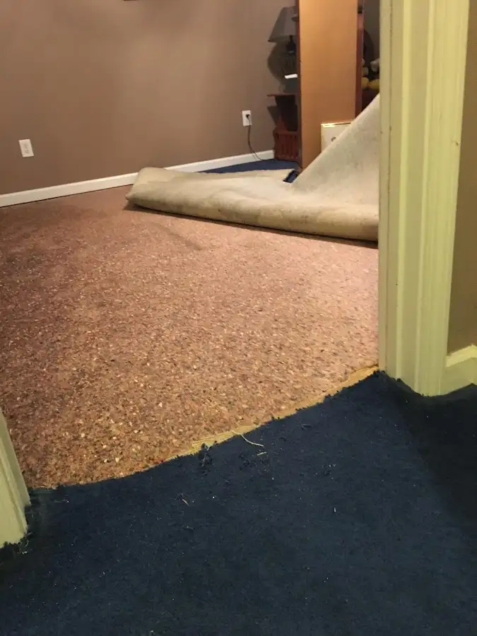 Carpet pad removal revealing water damage during Water Mitigation Services in Augusta